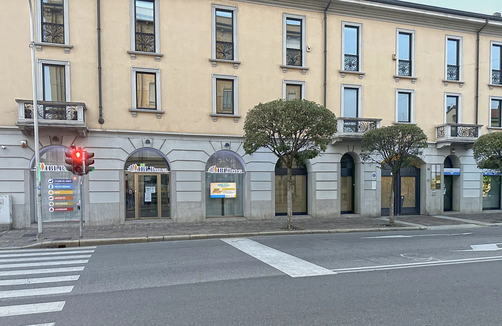 Street view of an IBL Banca branch façade with digital signage